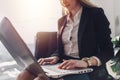 Young woman waiting in a hall sitting in modern office working on laptop talking on the phone Royalty Free Stock Photo