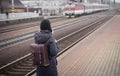 Young woman waiting train on the platform of railway station