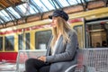 Young woman waiting for train to arrive on the platform at railway station Royalty Free Stock Photo