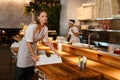 Young woman waitress disinfecting table in restaurant