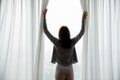 Young woman wake up open curtains at home