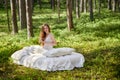 Young woman wakes up in a summer forest