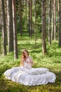 Young woman wakes up in a summer forest