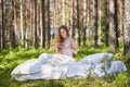 Young woman wakes up in a summer forest