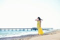 Young woman walk on an empty wild beach towards celestial beams of light falling from the sky Royalty Free Stock Photo