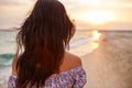 Young woman walk on an empty wild beach towards celestial beams of light falling from the sky, Royalty Free Stock Photo