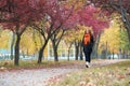 Young woman walk on footpath in autumn park, yellow leaves and trees Royalty Free Stock Photo