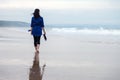 Young woman walking alone on a beach Royalty Free Stock Photo