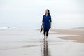 Young woman walking alone in a deserted beach Royalty Free Stock Photo
