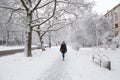 Young woman walking alone at empty snow-covered winter street. Snowy winter. Royalty Free Stock Photo