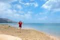 Young woman walking along beach by quiet bay in Hawaii Royalty Free Stock Photo