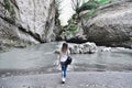 Young woman walking along canyon. Mountain river of Republic of Adygea in Russia.