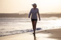 Young woman walking along ocean beach with waves Royalty Free Stock Photo