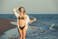 Young woman walking along sea or ocean beach at sunset Royalty Free Stock Photo