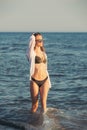 Young woman walking along sea or ocean beach at sunset Royalty Free Stock Photo