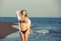 Young woman walking along sea or ocean beach at sunset Royalty Free Stock Photo