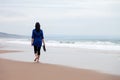Young woman walking away alone in a deserted beach Royalty Free Stock Photo