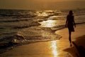 A young  woman is  walking on a beach at sunset, silhouette photography Royalty Free Stock Photo