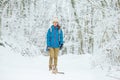 Young woman walking with a cat in snowy winter forest.