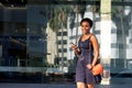 Young woman walking in city with earphones and mobile phone Royalty Free Stock Photo