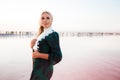 Young woman walking on Dead Sea with beautiful sky at pink sunrise Royalty Free Stock Photo