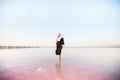 Young woman walking on Dead Sea with beautiful sky at pink sunrise Royalty Free Stock Photo