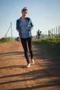 Woman walking on dirt track in countryside Royalty Free Stock Photo