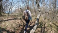 Young woman is walking in the forest with bagpack, active healthy traveler with walks along forest on spring sinshine