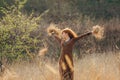 Young woman walking in golden dried grass field