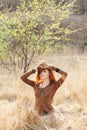 Young woman walking in golden dried grass field