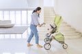 Young woman walking with her baby in a stroller Royalty Free Stock Photo