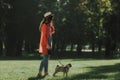 Young woman is walking with her dog in sunny park Royalty Free Stock Photo