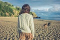 Young woman walking her dogs on beach at sunset Royalty Free Stock Photo