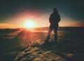 Young woman walks on hill above mist. Strong daybreak sun Royalty Free Stock Photo