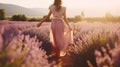 Young Woman Walking in Lavender Field on Sunny Day. Partial View of Girl Wearing Pink Dress in Row of Blooming Flower. Natural Royalty Free Stock Photo