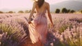 Young Woman Walking in Lavender Field on Sunny Day. Partial View of Girl Wearing Pink Dress in Row of Blooming Flower. Natural Royalty Free Stock Photo
