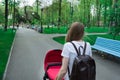 Young woman walking in the Park with baby stroller. Mother with newborn baby Royalty Free Stock Photo