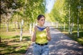 A young woman is walking in the park and putting on a medical mask on her face. Royalty Free Stock Photo