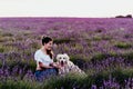 young woman walking on a purple lavender field with her golden retriever dog at sunset. Pets outdoors Royalty Free Stock Photo