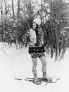 Young woman walking with snow shoes through the woods