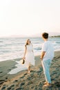 Young woman walking towards a man on the beach with a smile Royalty Free Stock Photo