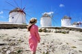 Young woman walking among traditional greek windmills on Mykonos island, Cyclades, Greece