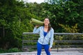 Young woman walking in urban park holding fitness rug. Royalty Free Stock Photo