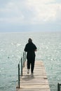 A young woman walking walking along the pier on Lake Ohrid in Macedonia. View from the back Royalty Free Stock Photo