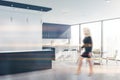 Young woman walking in white and blue kitchen Royalty Free Stock Photo