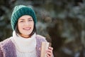 Young woman walking on winter day, holding travel stainless Steel mug with hot coffee. reusable water bottle