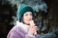 Young woman walking on winter day, holding travel stainless Steel mug with hot coffee. reusable water bottle