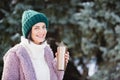 Young woman walking on winter day, holding travel stainless Steel mug with hot coffee. reusable water bottle