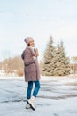 Young woman walking on winter day, holding travel stainless Steel mug with hot coffee. reusable water bottle