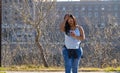 Young woman walking and worriedly looking at her cell phone in a park Royalty Free Stock Photo